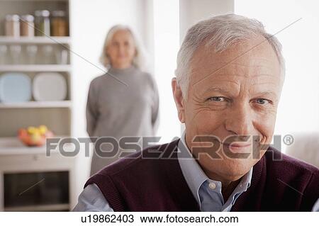 Portrait of smiling senior man, senior woman in background View Large Photo Image Stock Image - Portrait of smiling senior man, senior woman in background. Fotosearch