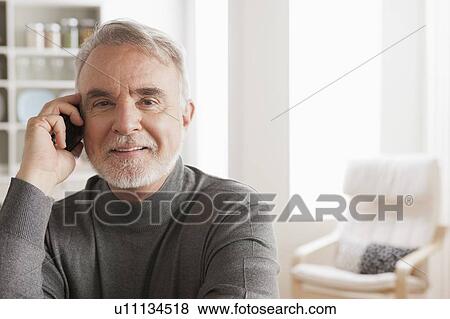 Stock Photo - Portrait of smiling senior man talking via mobile. Fotosearch