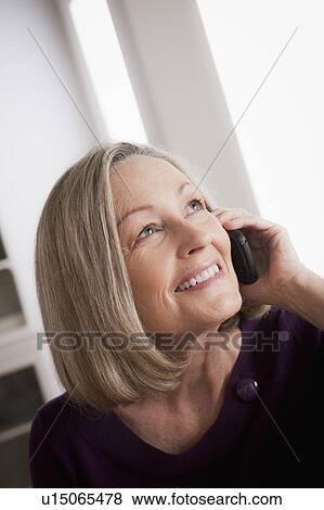 Stock Photo - Portrait of smiling senior woman talking via mobile. Fotosearch