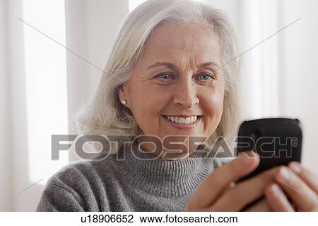 Portrait of smiling senior woman using mobile View Large Photo Image Stock Image - Portrait of smiling senior woman using mobile. Fotosearch