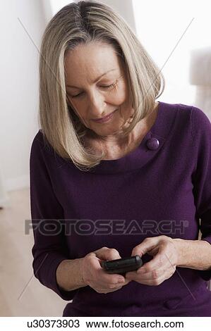 Portrait of smiling senior woman with mobile phone View Large Photo Image Stock Image - Portrait of smiling senior woman with mobile phone. Fotosearch