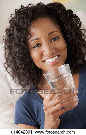 Portrait of smiling woman holding glass of water View Large Photo Image Stock Image - Portrait of smiling woman holding glass of water. Fotosearch