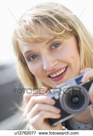 Portrait of smiling woman with camera View Large Photo Image Stock Photo - Portrait of smiling woman with camera. Fotosearch