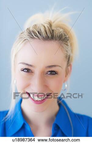 Portrait of smiling young woman, studio shot View Large Photo Image Picture - Portrait of smiling young woman, studio shot. Fotosearch