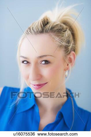 Stock Photograph - Portrait of smiling young woman, studio shot. Fotosearch