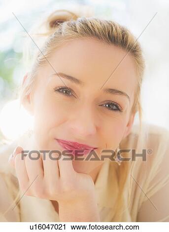 Stock Image - Portrait of smiling young woman with blonde hair. Fotosearch