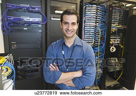 Portrait of technician in network server room View Large Photo Image Stock Photo - Portrait of technician in network server room. Fotosearch