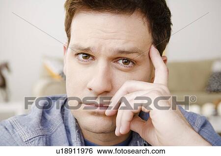 Stock Photograph - Portrait of thoughtful mid adult man. Fotosearch