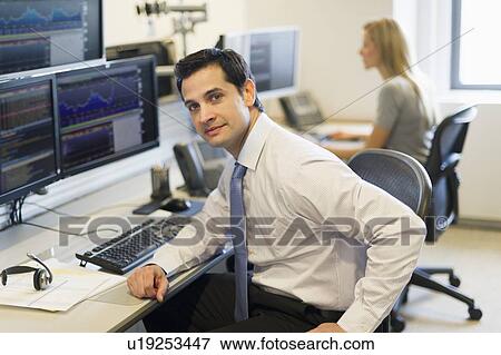 Stock Photo - Portrait of trader at trading desk. Fotosearch