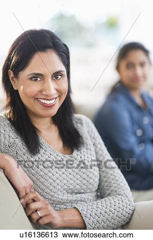 Stock Image - Portrait of woman, daughter (12-13) in background. Fotosearch