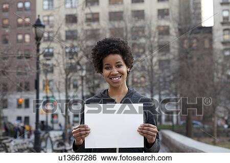 Portrait of woman holding blank paper View Large Photo Image Stock Photograph - Portrait of woman holding blank paper. Fotosearch