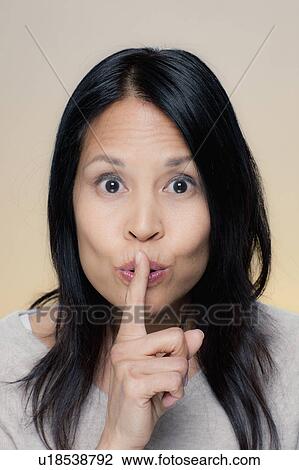 Portrait of woman making silence gesture View Large Photo Image Stock Image - Portrait of woman making silence gesture. Fotosearch