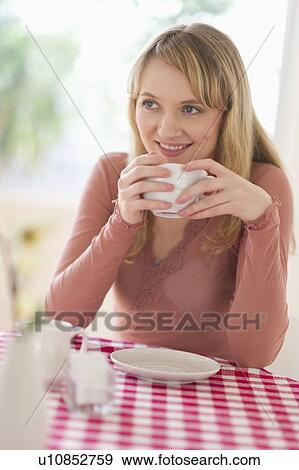 Portrait of woman sitting at table View Large Photo Image Stock Photo - Portrait of woman sitting at table. Fotosearch