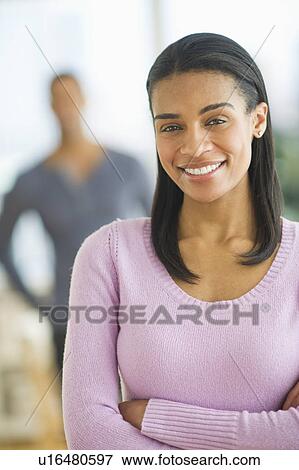 Portrait of woman smiling, man in background View Large Photo Image Stock Photo - Portrait of woman smiling, man in background. Fotosearch