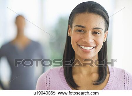 Portrait of woman smiling, man in background View Large Photo Image Stock Photography - Portrait of woman smiling, man in background. Fotosearch