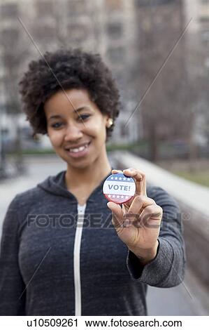 Stock Image - Portrait of woman with vote pin. Fotosearch