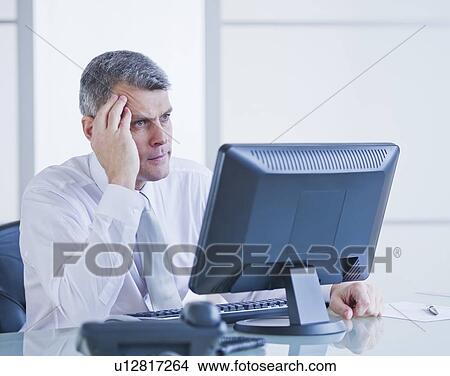 Portrait of worried businessman working at desk View Large Photo Image Picture - Portrait of worried businessman working at desk. Fotosearch