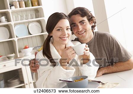 Stock Image - Portrait of young couple at breakfast. Fotosearch