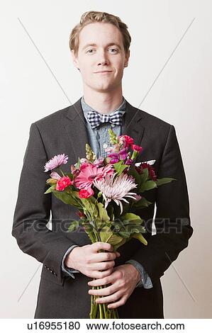 Portrait of young handsome man holding bunch of flowers View Large Photo Image Stock Image - Portrait of young handsome man holding bunch of flowers. Fotosearch