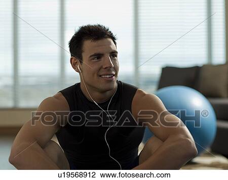 Stock Image - Portrait of Young man exercising at home. Fotosearch