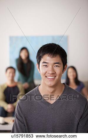 Portrait of young man with family in background View Large Photo Image Stock Image - Portrait of young man with family in background. Fotosearch