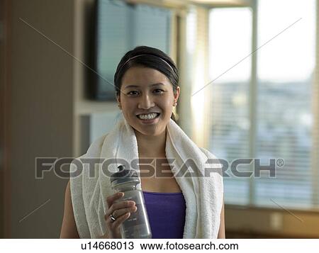 Stock Image - Portrait of Young woman exercising at home. Fotosearch