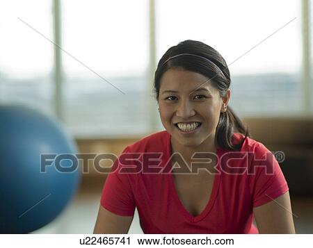 Stock Image - Portrait of Young woman exercising at home. Fotosearch
