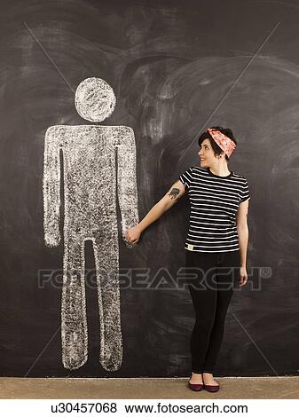 Portrait of young woman in front of blackboard View Large Photo Image Stock Photo - Portrait of young woman in front of blackboard. Fotosearch
