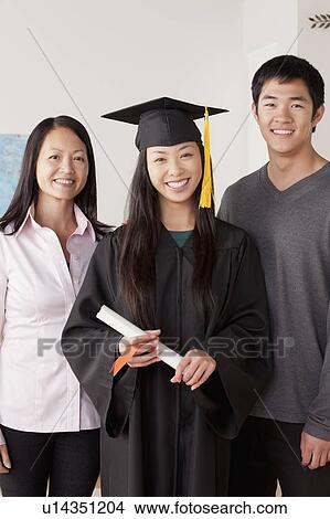Picture - Portrait of young woman in graduation gown with mother and brother. Fotosearch