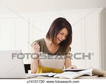 Stock Image - Portrait of young woman learning at home. Fotosearch