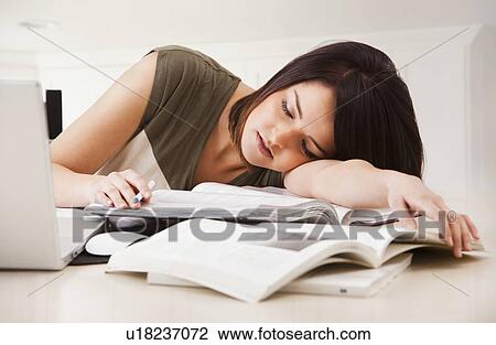 Stock Image - Portrait of young woman learning at home. Fotosearch