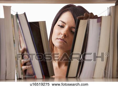 Portrait of young woman searching book on shelf View Large Photo Image Stock Photography - Portrait of young woman searching book on shelf. Fotosearch