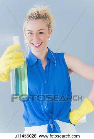 Portrait of young woman spraying cleaning detergent, studio shot View Large Photo Image Stock Photo - Portrait of young woman spraying cleaning detergent, studio shot. Fotosearch