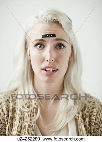 Stock Image - Portrait of young woman with word help on forehead. Fotosearch