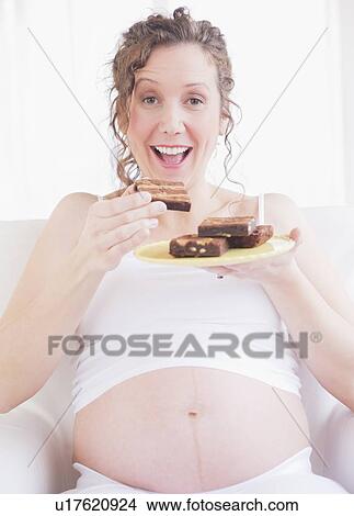 Pregnant woman eating cake View Large Photo Image Picture - Pregnant woman eating cake. Fotosearch