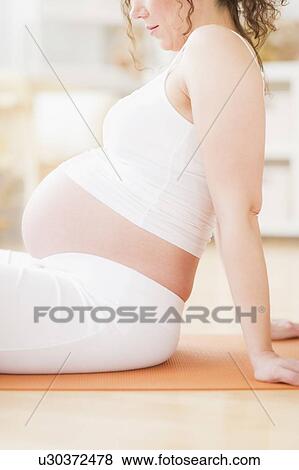 Pregnant woman practicing yoga View Large Photo Image Stock Photo - Pregnant woman practicing yoga. Fotosearch