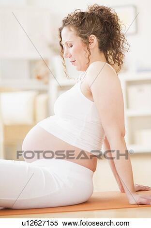 Stock Photography - Pregnant woman practicing yoga. Fotosearch