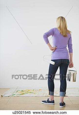 Rear view of woman holding paint can and paint roller View Large Photo Image Stock Photography - Rear view of woman holding paint can and paint roller. Fotosearch