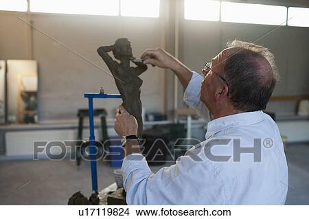 Picture - Retired man working on sculpture. Fotosearch
