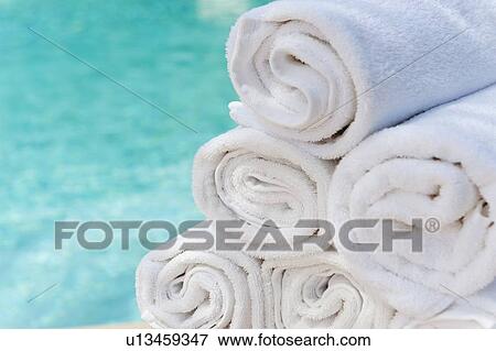 Rolled up towels in front of water View Large Photo Image Stock Photo - Rolled up towels in front of water. Fotosearch