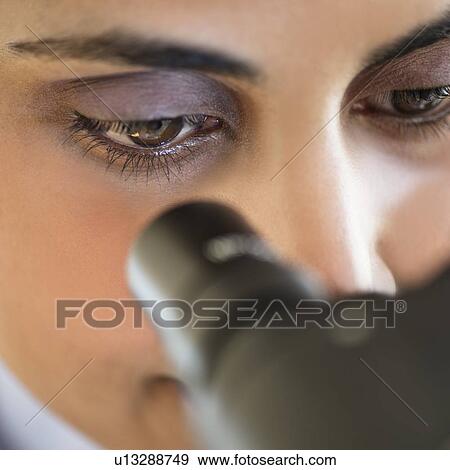 Stock Photo - Scientist looking through microscope. Fotosearch
