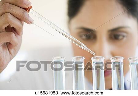 Scientist pipetting liquid into test tubes View Large Photo Image Stock Image - Scientist pipetting liquid into test tubes. Fotosearch