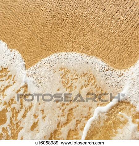 Stock Photo - Sea waves on beach sand. Fotosearch