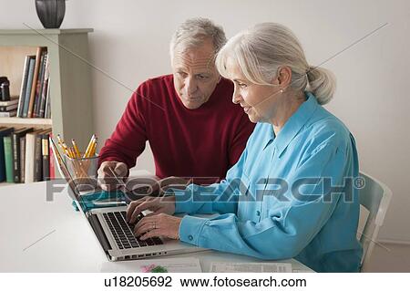 Senior couple using laptop together View Large Photo Image Stock Image - Senior couple using laptop together. Fotosearch