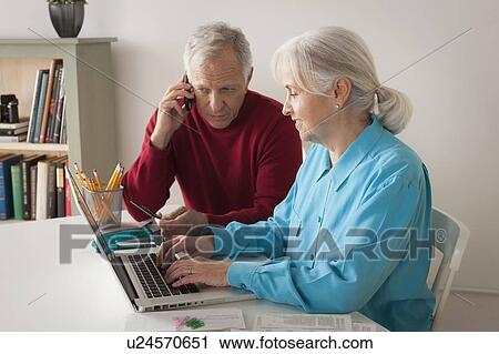 Stock Image - Senior couple using laptop together. Fotosearch