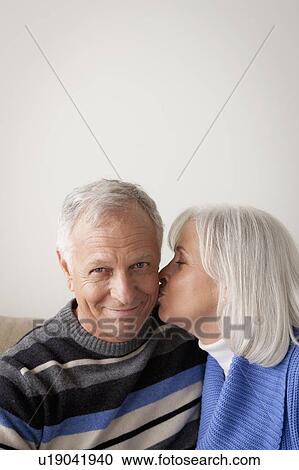 Stock Image - Senior couple, woman kissing man. Fotosearch