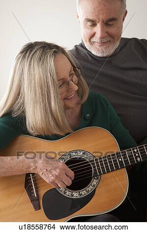 Picture - Senior couple, woman playing guitar. Fotosearch