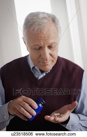 Stock Photograph - Senior man holding medicine bottle. Fotosearch