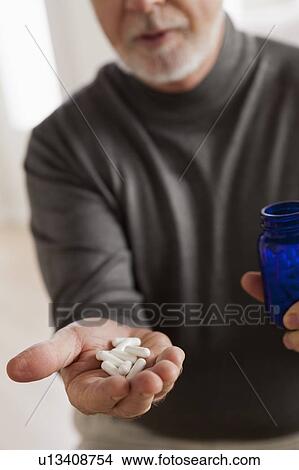 Senior men holding pills View Large Photo Image Picture - Senior men holding pills. Fotosearch