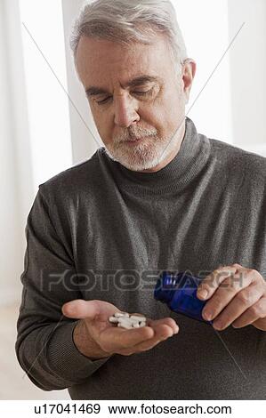 Senior men holding pills View Large Photo Image Stock Photo - Senior men holding pills. Fotosearch